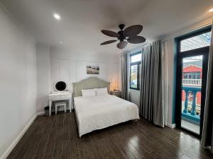a bedroom with a bed and a ceiling fan at Sea La Vie Wonderland Hồ Tràm in Ho Tram +6 photos