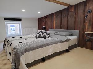 a bedroom with a large bed with wooden walls at Courtyard Condo Sunset in Liepāja