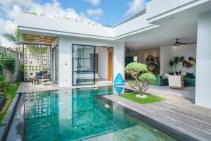 a swimming pool in a villa with a house at Stylish 2bedroom Villa Canggu Padonan in Kerobokan
