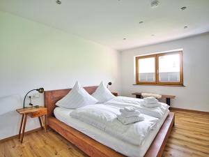 Un dormitorio con una cama grande con sábanas blancas. en FeWo Weinbuch, en Bischofswiesen