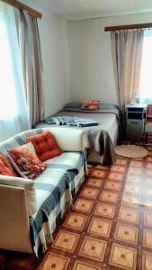 a bedroom with a bed and a couch in a room at Ciemos pie Ingas 2 in Smiltene +2 photos