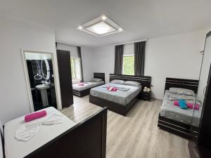 a large room with two beds and a mirror at Bujtina Lecaj in Selcë