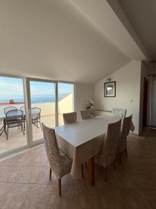 a dining room with a table and chairs with a view at Guest House Katarina in Malinska