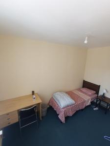 a room with two beds and a desk and a table and a desk at Beautiful private room in apartment in Saint-Pierre-des-Corps