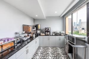 a kitchen with white cabinets and a large window at Days Inn by Wyndham New York Chinatown in New York