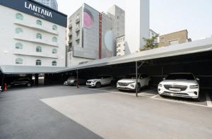 un parcheggio con auto parcheggiate di fronte a un edificio di Hotel Lantana Sangmu a Gwangju