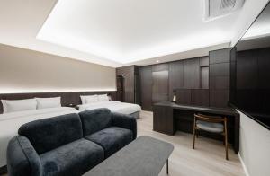 una camera d'albergo con un divano e due letti di Hotel Lantana Sangmu a Gwangju