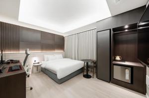 una camera d'albergo con un letto e una scrivania di Hotel Lantana Sangmu a Gwangju