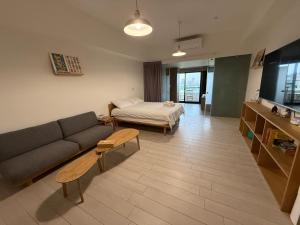a living room with a couch and a bed at Sunrise Hot Spring House in Toucheng