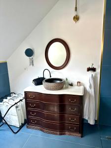 a bathroom with a sink and a mirror on a dresser at Dock Cottage House in Bădeni