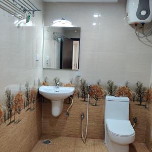 a bathroom with a sink and a toilet and a mirror at Ravila Grand Hotel in Lingampalli +61 photos
