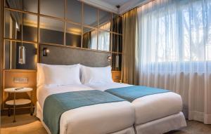 a bedroom with a large bed and a window at Barceló Emperatriz in Madrid