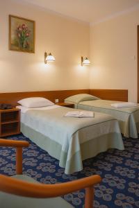 Ośrodek Wczasowy Mega - pokoje przy promenadzie في كولوبرزيغ: غرفة فندقية بسريرين وكرسيين