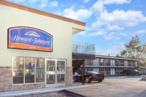 a front of a hotel with a car parked outside at Howard Johnson Inn by Wyndham Kingston in Kingston
