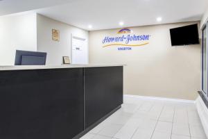a reception desk in a dental office with a sign on the wall at Howard Johnson Inn by Wyndham Kingston in Kingston