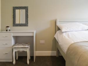 a bedroom with a bed and a dresser with a mirror at Two Dorchester Drive - Uk32036 in Inglewhite