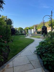a walkway through a garden with a park with at The Resting Shepherd in Angmering