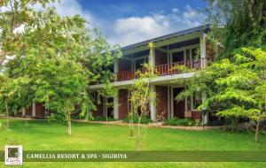 an exterior view of a house with trees at Camellia Resort And Spa Sigiriya - Sri Lanka in Avudangawa