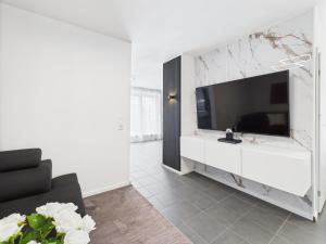 a living room with a tv and a white wall at Loft and Living Private Spa am See mit Sauna und Whirlpool in Braunsbedra