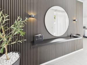 a bathroom with a mirror on a striped wall at Loft and Living Private Spa am See mit Sauna und Whirlpool in Braunsbedra +32 photos