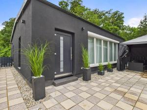 a black house with plants in front of it at Loft and Living Private Spa am See mit Sauna und Whirlpool in Braunsbedra