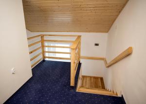 um quarto com um tecto de madeira e uma escada em Agroturystyka SzumyNowiny em Majdan Sopocki
