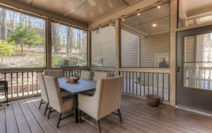 a screened in porch with a wooden table and chairs at Dennys Caribou Lodge -Dog Friendly Stone Fireplace King Suites in Jasper