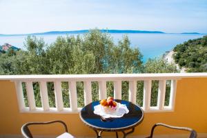 a table with a bowl of fruit on a balcony at Vila Tatinja in Trogir