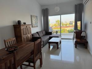 ein Wohnzimmer mit Sofa und Tisch in der Unterkunft Paradise Gardens 1 in Paphos City