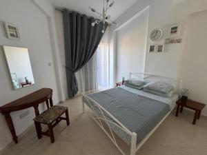 ein Schlafzimmer mit einem Bett und einem Tisch und einem Fenster in der Unterkunft Paradise Gardens 1 in Paphos City