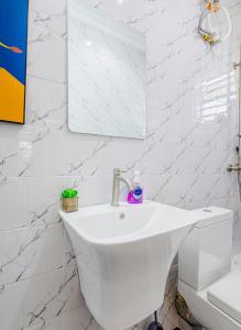 a white bathroom with a sink and a mirror at Chique 1BR Villa with Lush Garden Nakuru Town in Nakuru