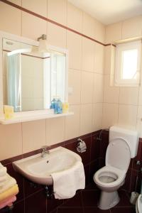 a bathroom with a sink and a toilet and a mirror at Apartments Hari Tisno in Tisno +67 photos