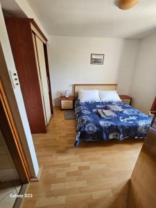 a bedroom with a bed and a wooden floor at Apartmani Maria in Preko