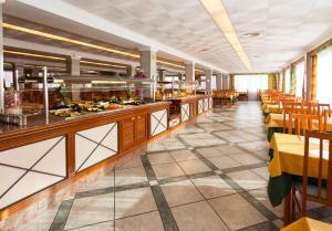 a restaurant with a buffet line with tables and chairs at Hotel Riutort in El Arenal