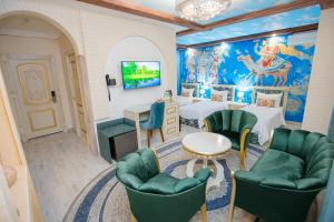 a room with green chairs and a painting on the wall at Gur Emir Palace boutique hotel in Samarkand