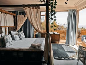 1 dormitorio con cama con dosel y ventana grande en Seascape Camps Bay, en Ciudad del Cabo 138 fotos más