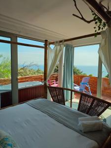 1 dormitorio con 1 cama y sillas en el balcón en Seascape Camps Bay, en Ciudad del Cabo