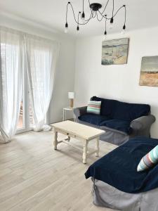 a living room with a couch and a coffee table at T3 refait à neuf vue mer en centre ville parking in Bandol