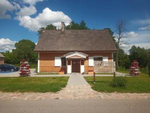 a small building with a sign in front of it at Dom dziedzictwa in Korycin