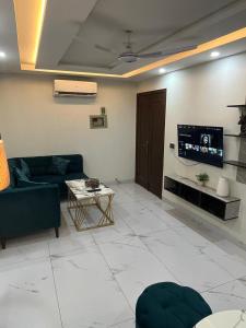 a living room with a couch and a tv at Staycation Apartments in Lahore