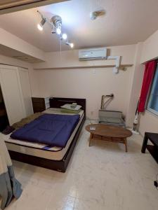 Un dormitorio con una cama grande y una mesa. en RoseMarieSapporo, en Sapporo 2 fotos más