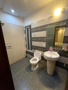 a bathroom with a toilet and a sink at Staycation Apartments in Lahore