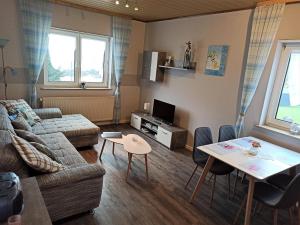 a living room with a couch and a table at Ferienhaus Gönen in Bleialf