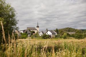 a village with a church in the middle of a field at Zur Dorfschänke in Hausen