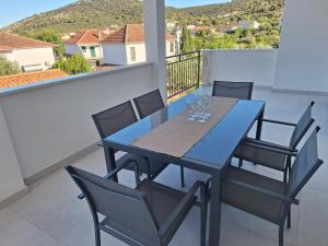 a blue table and chairs on a balcony at Apartmani Jerka in Vinišće