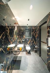 a bathroom with two sinks and a flat screen tv at The Enchanted Nest By Privy Stays in Alibag