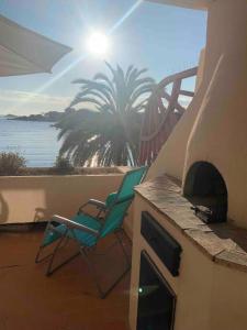 un patio avec une chaise et une cheminée avec vue sur l'océan dans l'établissement Terrasse avec superbe vue mer & pieds dans l’eau, à Bandol