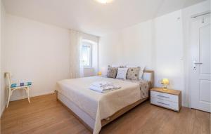 a white bedroom with a bed and a wooden floor at Lovely Home In Brbinj With Wifi in Brbinj +38 photos