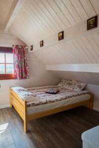 a small bed in a attic room with a window at Znamirówka in Znamirowice