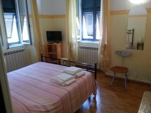 萊里奇的住宿－Affittacamere "In Piazzetta da Vasco"，一间卧室配有一张床,上面有两条毛巾